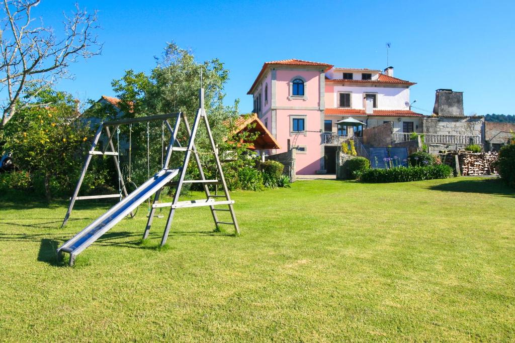 un'altalena in un cortile con una casa di Dias House a Viana do Castelo