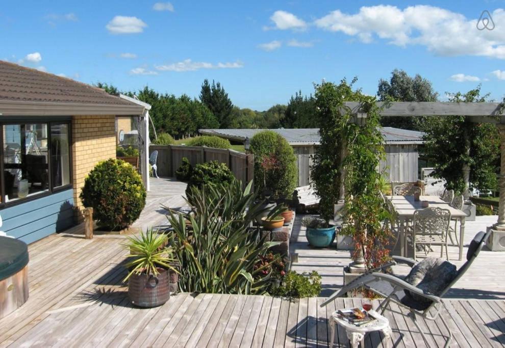 a backyard with a wooden deck with plants at Applaud BnB in Drury