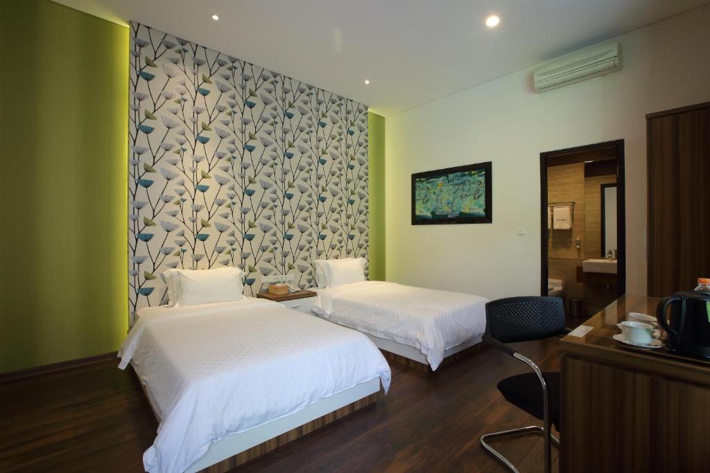 a hotel room with two beds and a tv at Dago Teuku Angkasa 14 in Bandung
