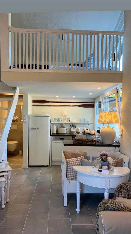 a living room with a staircase and a kitchen at Ferienwohnung MALIBU S am See in Wettringen