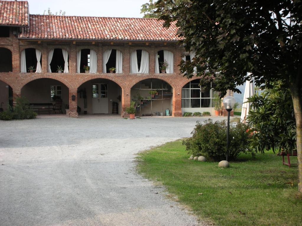 un grande edificio in mattoni con un vialetto di fronte di Agriturismo Minaldo a Dogliani