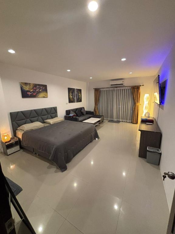 a bedroom with a bed and a couch at Lamai Beachroad Apartment in Lamai