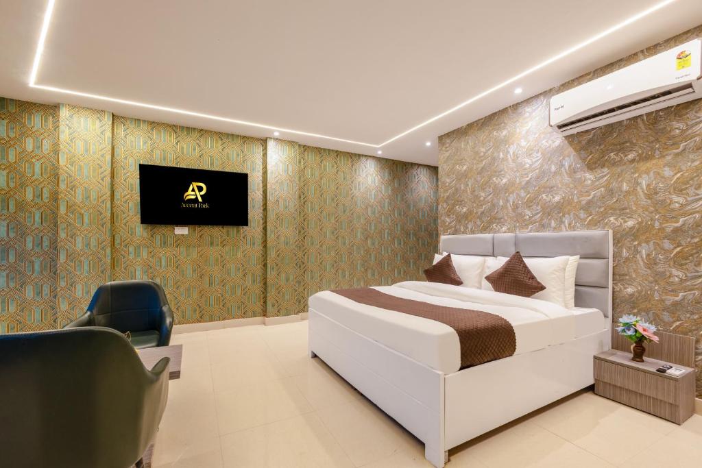 a bedroom with a white bed and a chair at Accent Park Hotel Near Barclays Sec 62 Noida in Noida