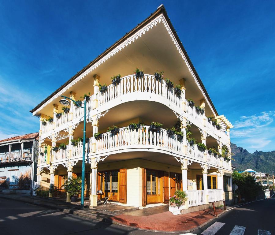 un edificio con un balcón con macetas. en Tsilaosa Hôtel en Cilaos