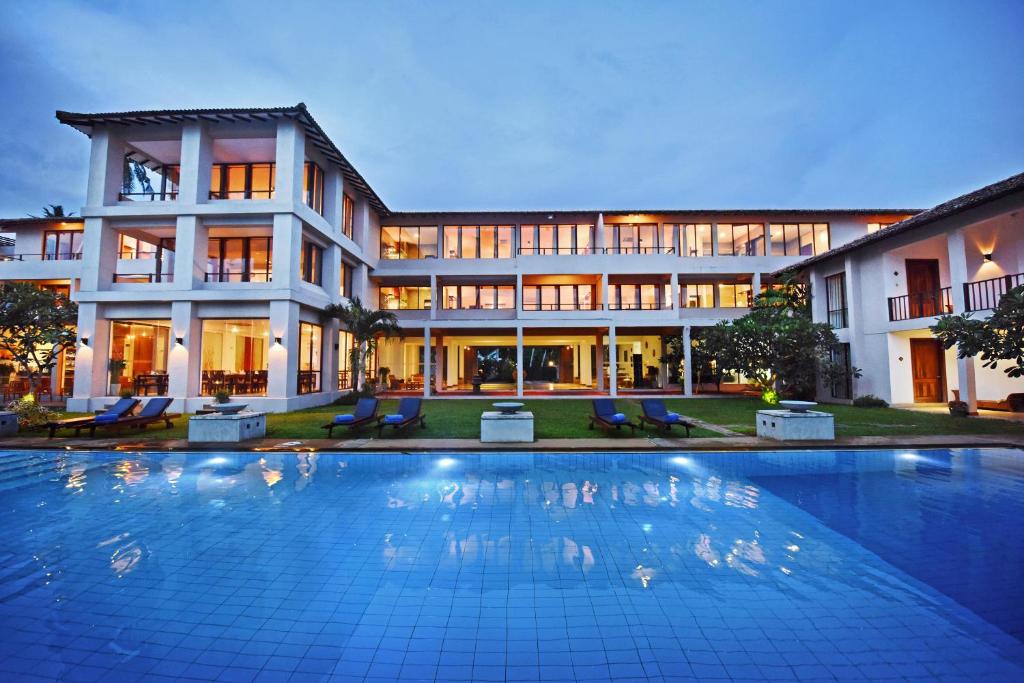- un grand bâtiment avec une piscine en face dans l'établissement Mandara Resort Mirissa, à Mirissa