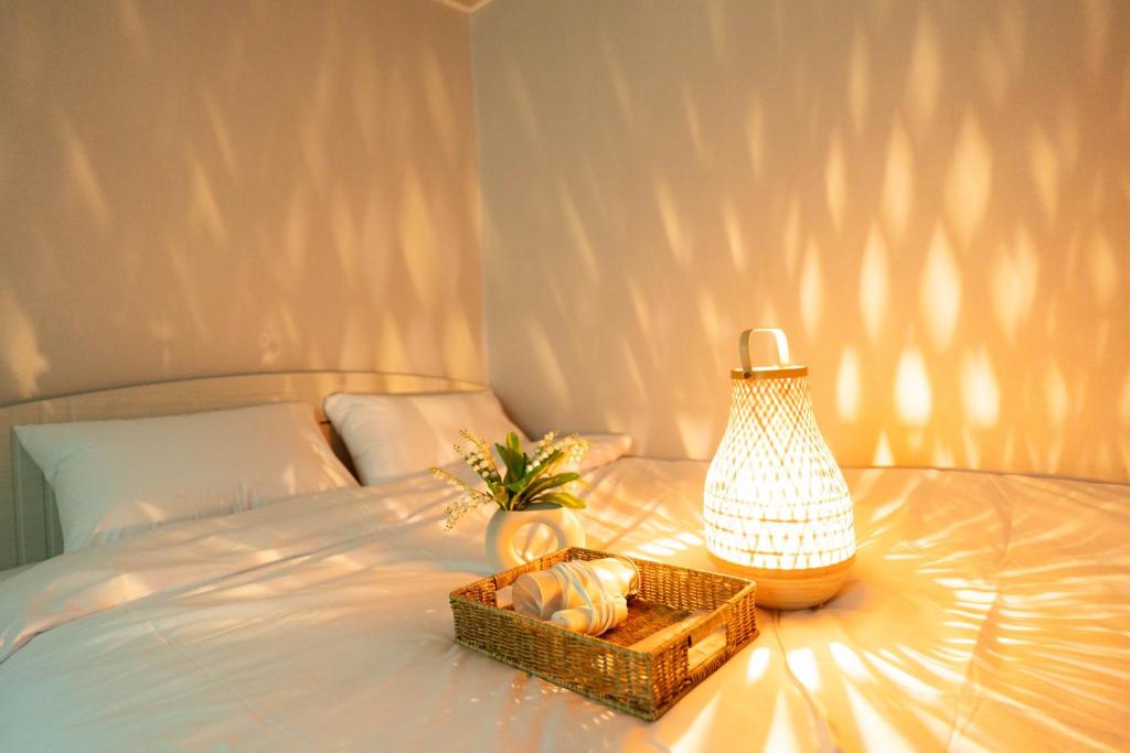 a basket of bread and a lamp on a bed at Hillzo stay in Seoul
