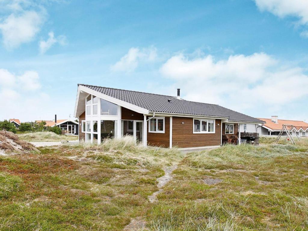 a house on a hill with a grass field at 10 person holiday home in Thisted-By Traum in Klitmøller
