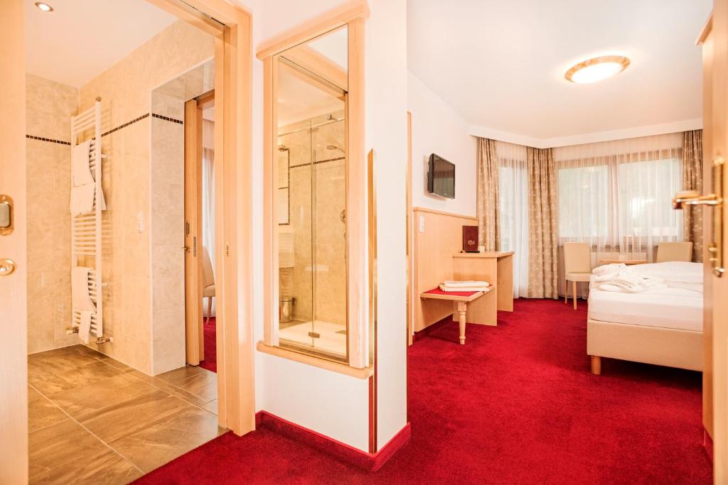 Postel nebo postele na pokoji v ubytování Hotel Alpenhof Kristall