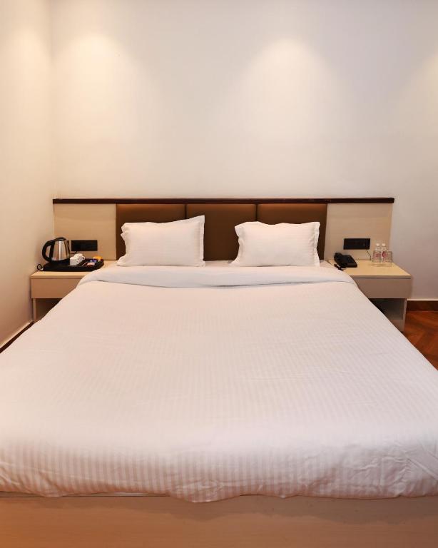 a bedroom with a large white bed with two pillows at Shree Jayati Inn in Ayodhya