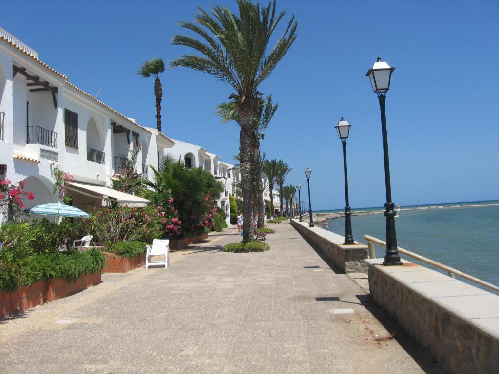 eine Straße mit Palmen und Gebäuden am Meer in der Unterkunft Apartamento en Aldeas de Taray club in La Manga del Mar Menor