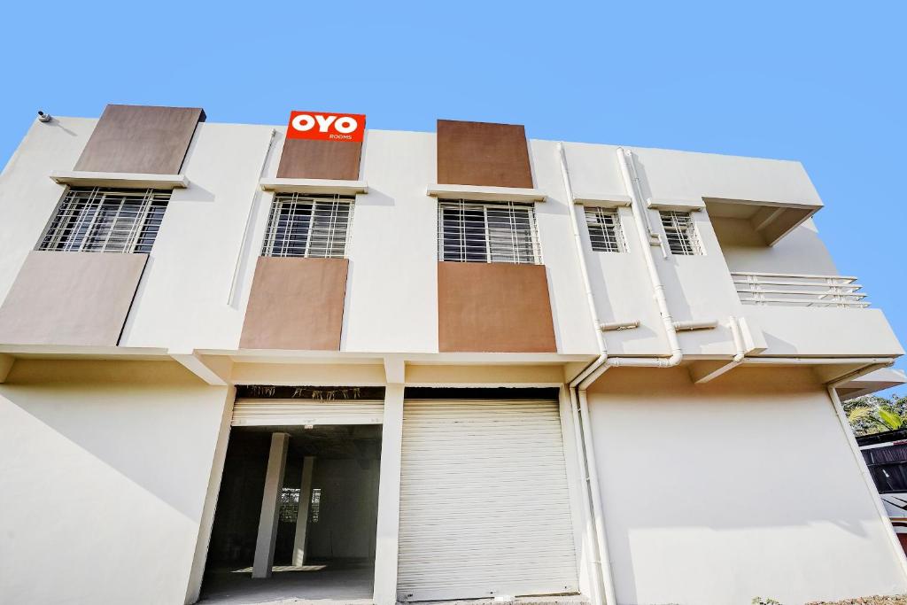 een wit gebouw met een ccnos-bord erop bij Hotel O Yashraj Inn in Nagpur