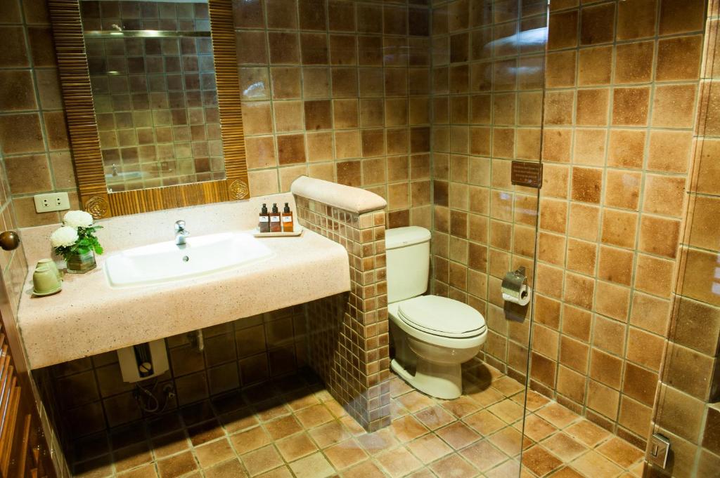 a bathroom with a toilet and a sink at Montien House - SHA Plus in Chaweng