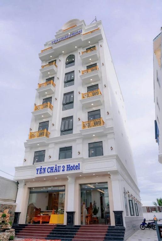 a tall white building with a sign on it at khách sạn yên châu 2 in Chau Doc