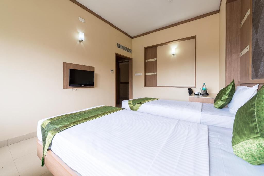 Postel nebo postele na pokoji v ubytování Treebo ESS Grande