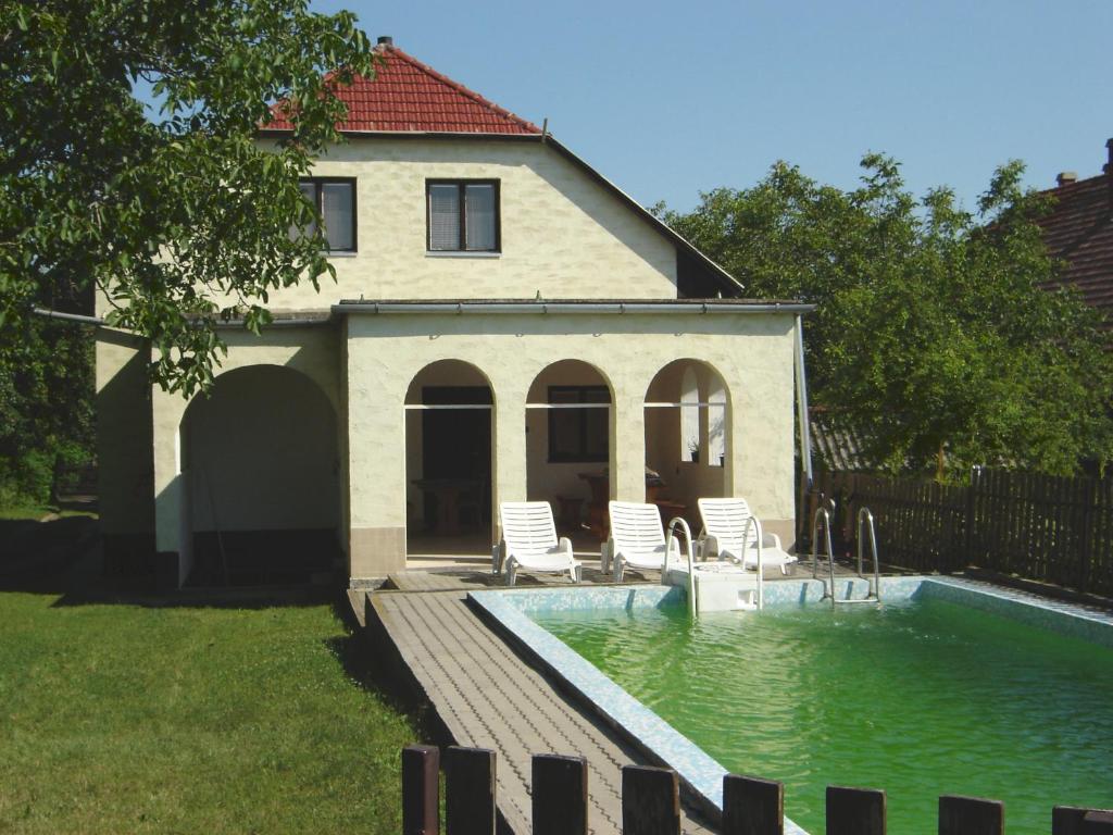 a house with a swimming pool in the yard at Somogyi Vendégház in Zamárdi