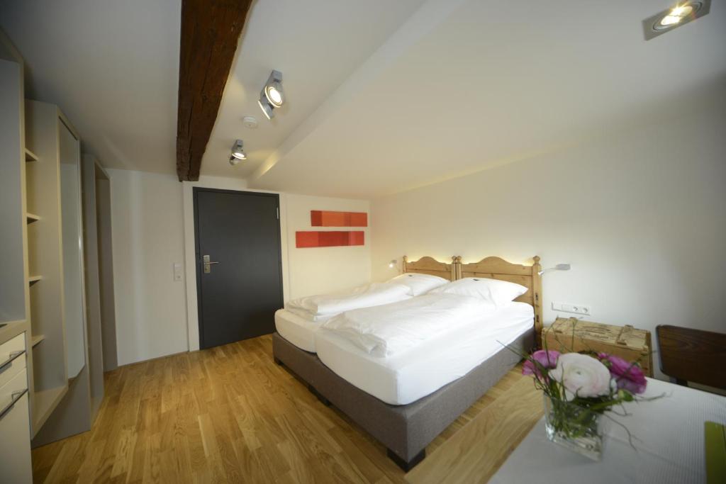 ein Schlafzimmer mit einem Bett und einem Tisch mit Blumen in der Unterkunft Gasthaus Hirsch in Ersingen