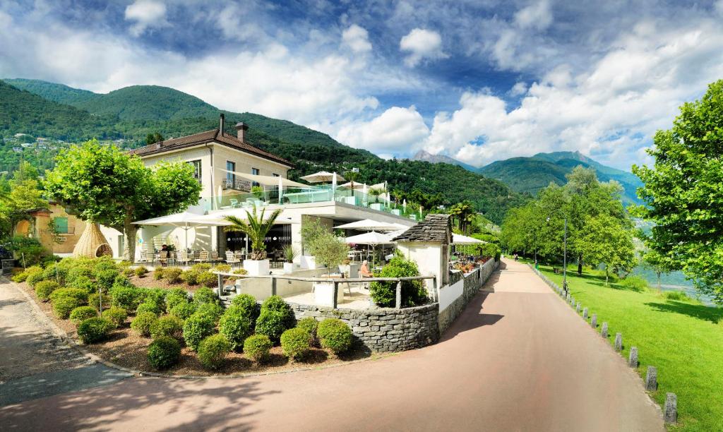 a house on the side of a river at Giardino Lago in Locarno