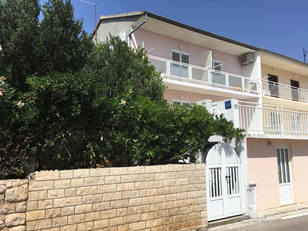 una casa blanca con una pared y una valla en Apartments Katnić, en Hvar