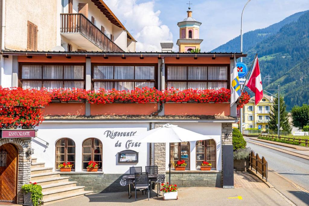 a building with an umbrella in front of it at Lardi Hotel & Ristorante, Le Prese Valposchiavo in Le Prese, Poschiavo