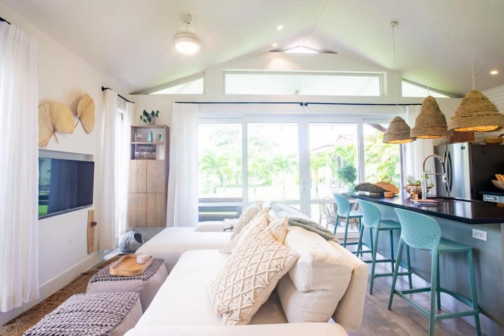 Una sala de estar con un sofá blanco y una cocina. en Villa Del Mar - Blue Venao 3BR, en Playa Venao