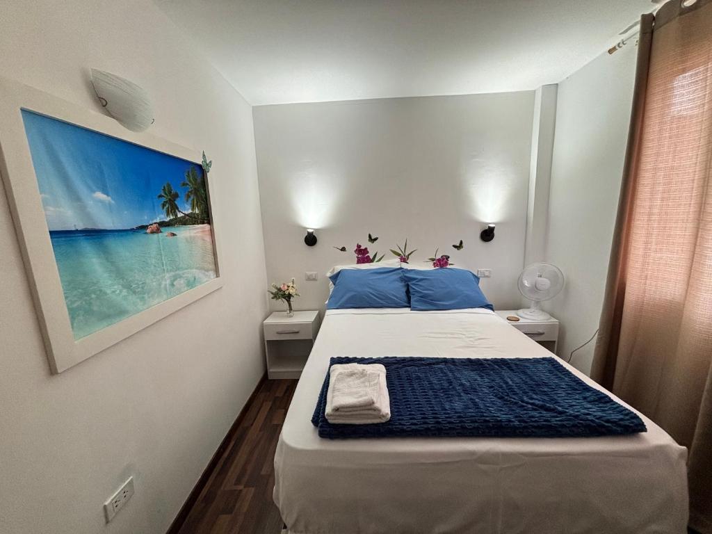 1 dormitorio con 1 cama y una foto del océano en Mini Apartamento con Aire acondicionado, en Tumbes
