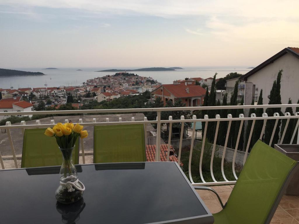 a table with a vase of flowers on a balcony at Apartments Rube in Primošten