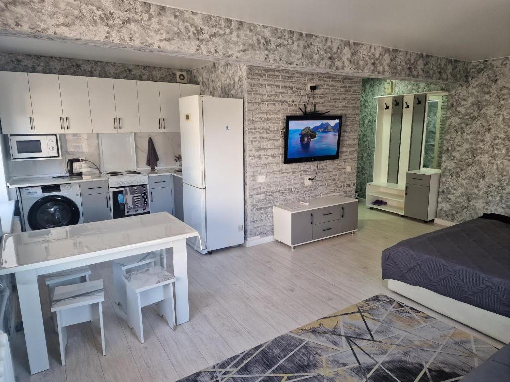 a room with a kitchen and a living room at Сдаётся однокомнатная квартира Люкс возле озера. in Balqash