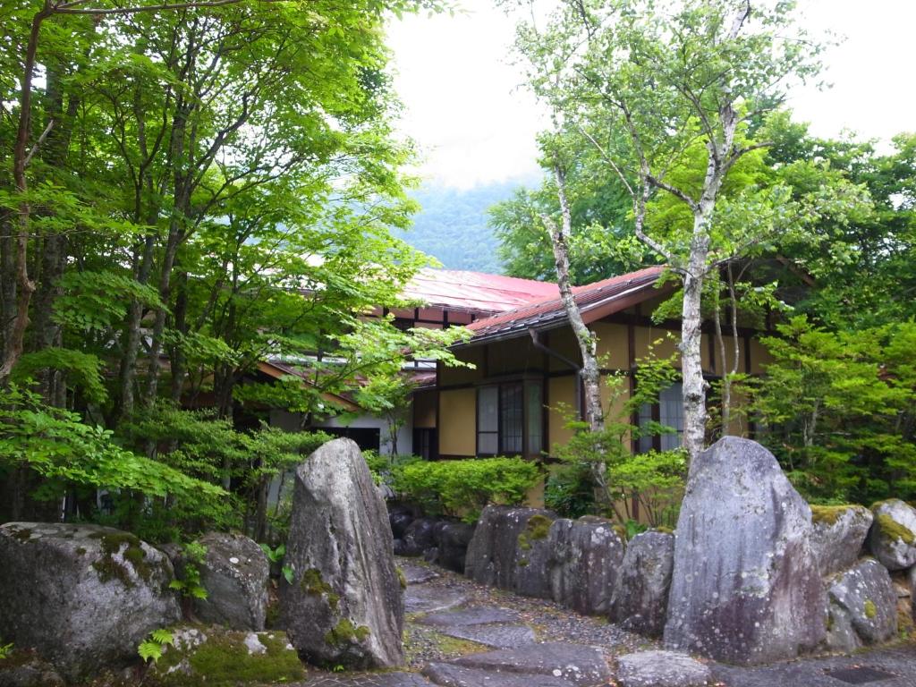 um jardim com pedras em frente a um edifício em Pension Kinoshita em Takayama