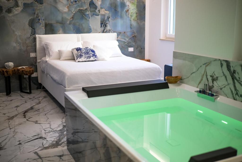 La salle de bains est pourvue d'une baignoire à côté d'un lit. dans l'établissement Suite 18, à Polignano a Mare