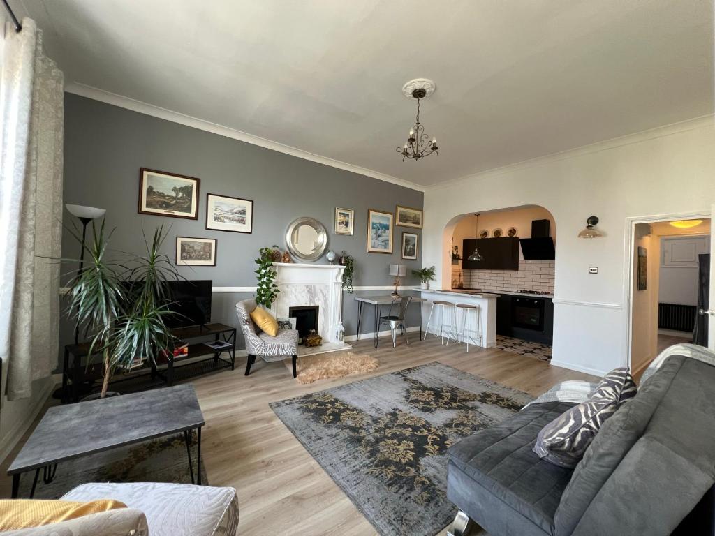 ein Wohnzimmer mit Sofa und Kamin in der Unterkunft Sea Spray Victorian Apartment in St. Leonards