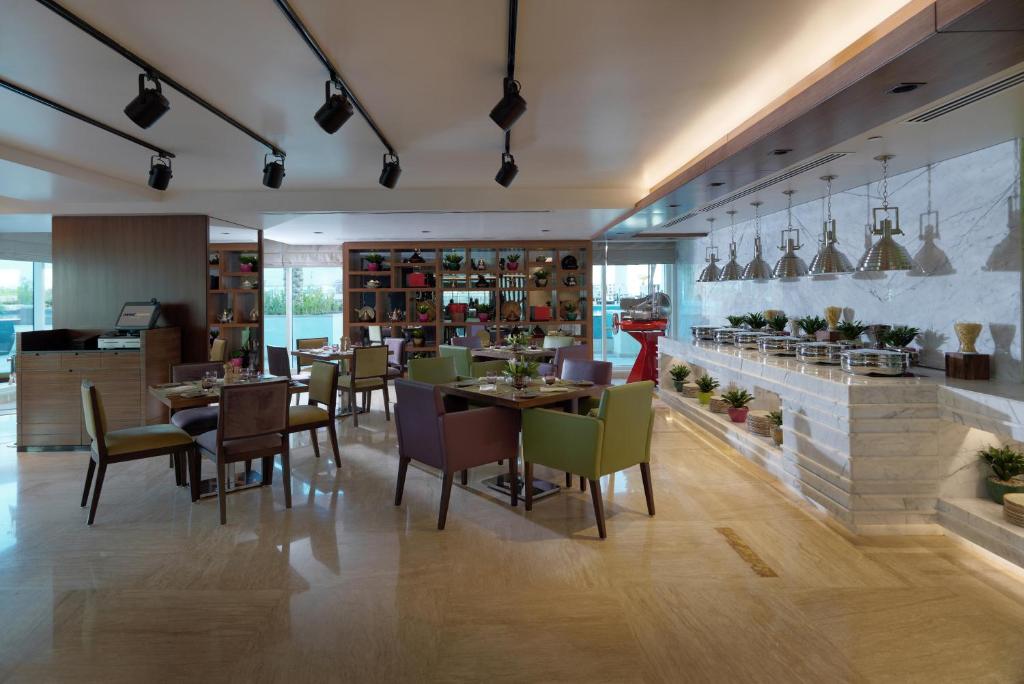 a restaurant with tables and chairs in a room at DAMAC Maison Canal Views in Dubai