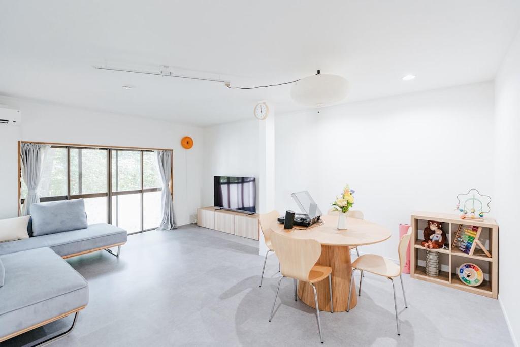 a living room with a table and a couch at Geisha Blue Ryusenji in Kasugai