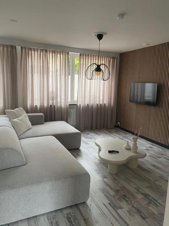 una sala de estar con un sofá y una mesa en Aan de Plenkert, en Valkenburg