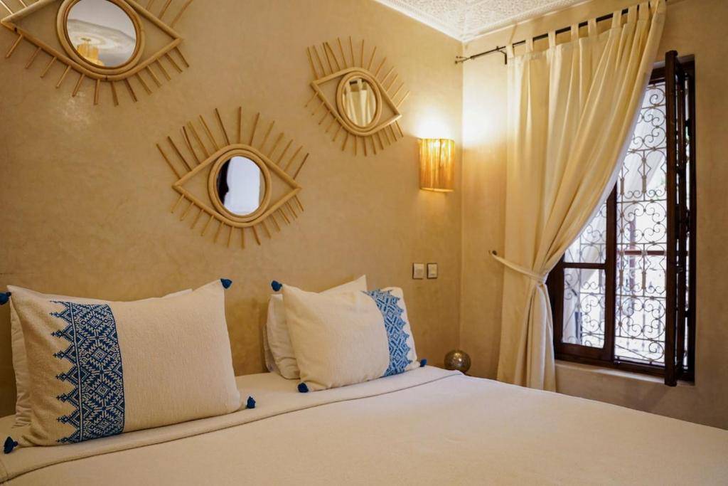 a bedroom with a bed with pillows and a window at Riad Tecla in Marrakech
