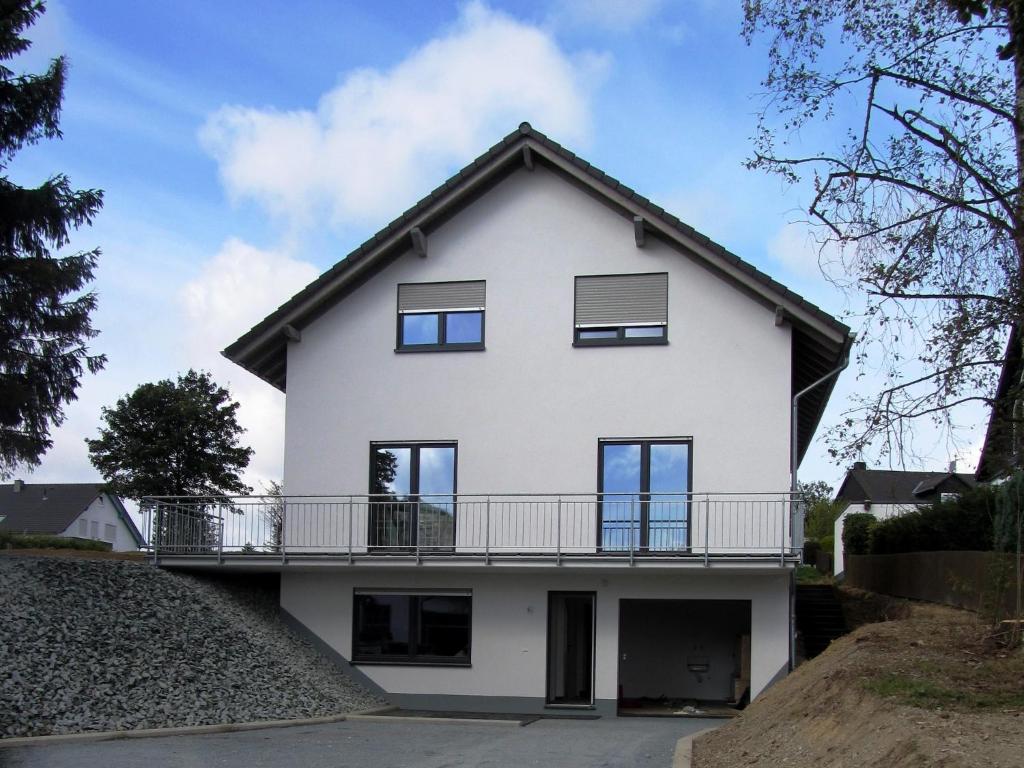 a large white house with a balcony at Moderne Villa in Medebach Küstelberg in Medebach