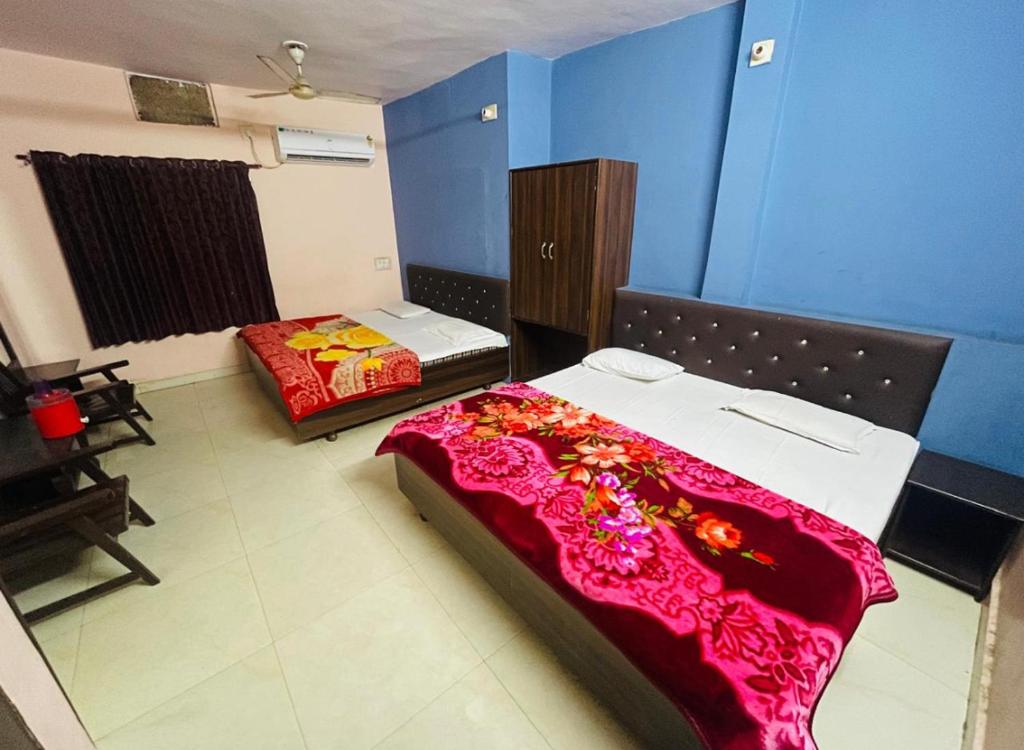 ウダイプールにあるHotel vallabh darshanの青い壁の部屋にベッドが2つある