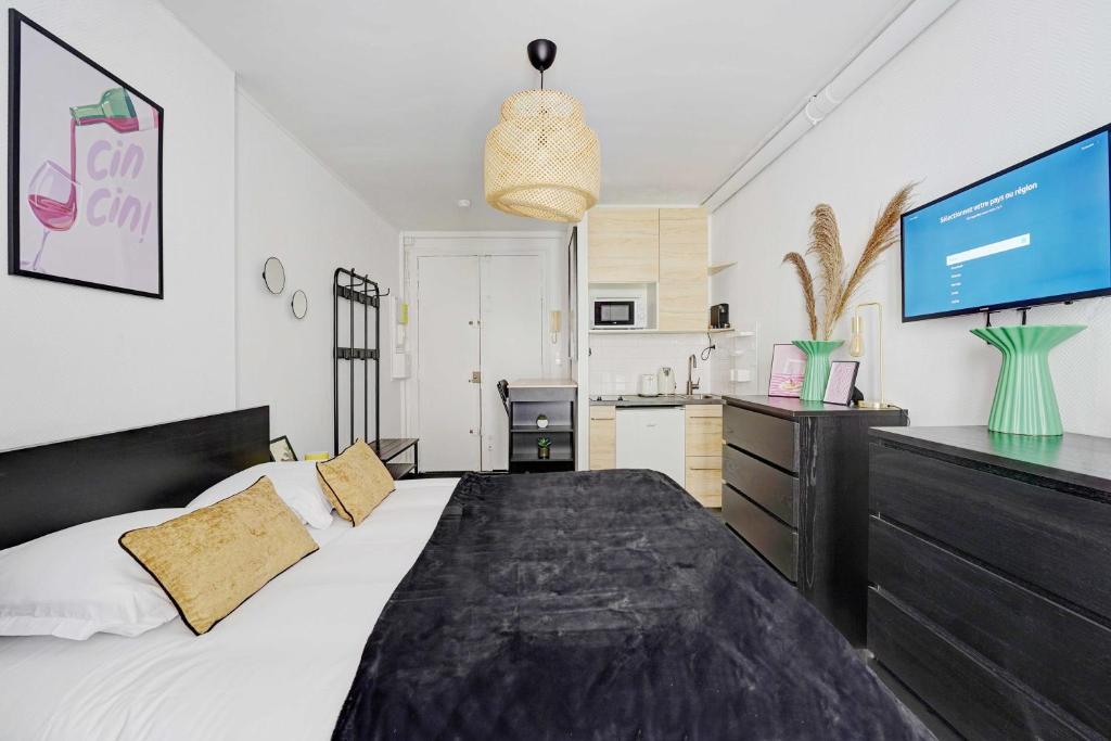 a bedroom with a large bed and a tv at Charming studio - 2P - Batignolles in Paris