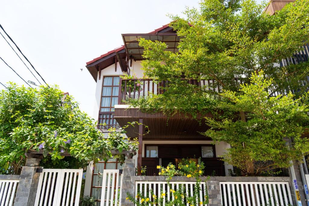 ホイアンにあるAuLac Hoian Homestayの柵と木が目の前の建物