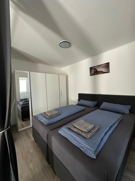 Un dormitorio con una cama con sábanas azules y un espejo. en Star Ferien Appartement, en Otterndorf