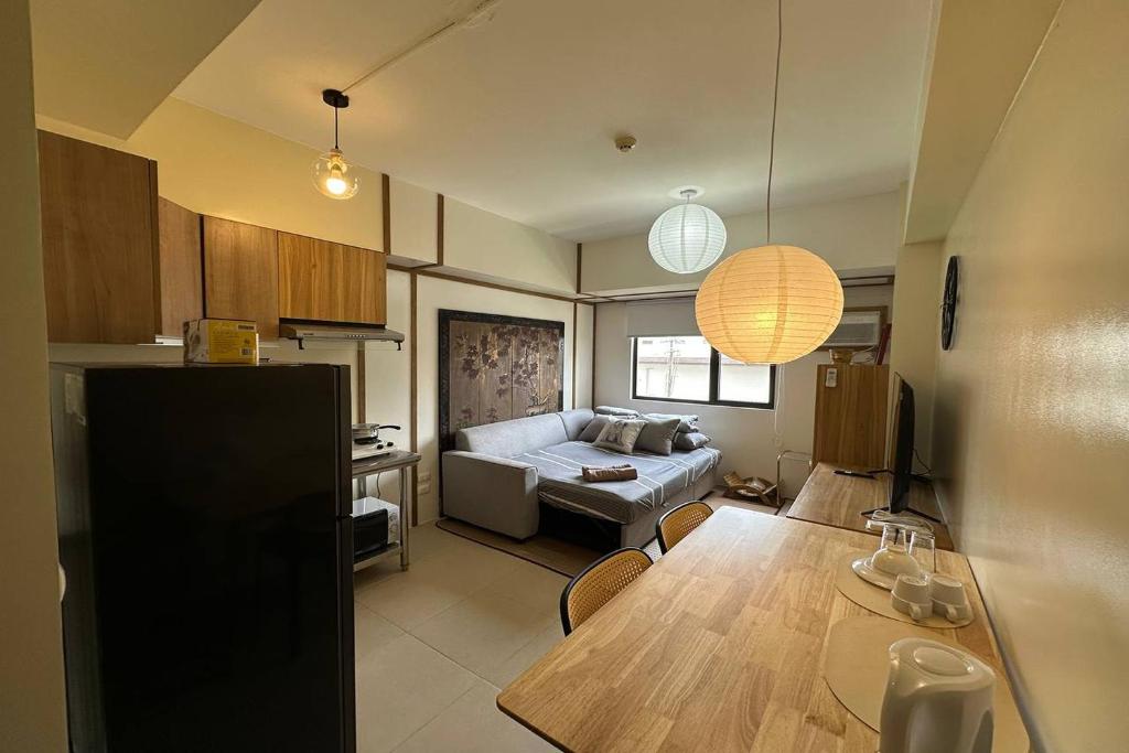 a kitchen and living room with a table and a couch at Avida Units Staycation near Ayala Serin Tagaytay in Kaybagal