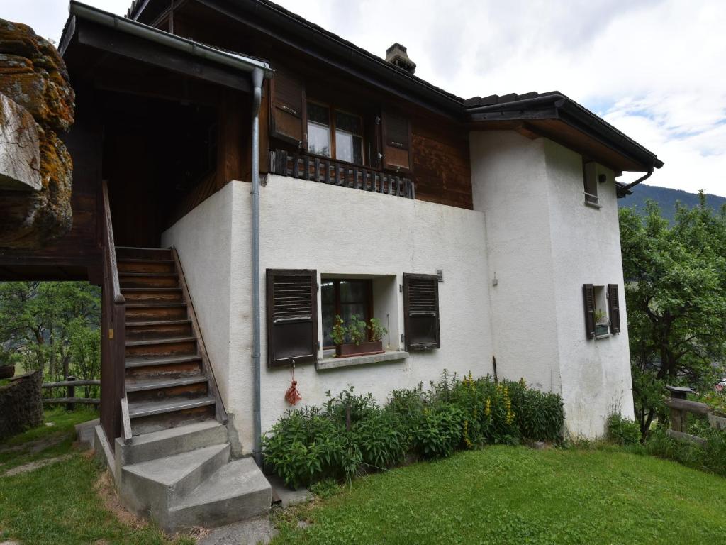 a white house with a staircase and a window at Cozy Stay near Aletsch in Grengiols