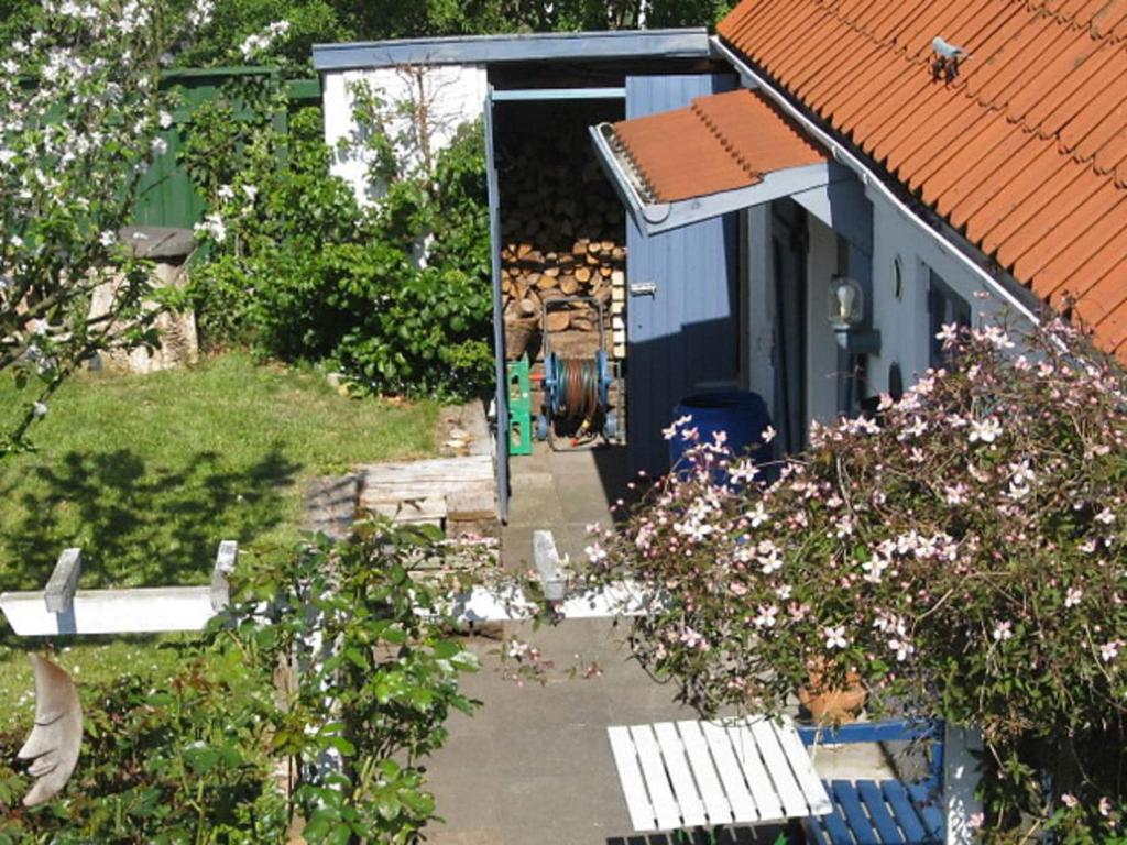 une maison avec un banc et des fleurs devant elle dans l'établissement 4 person holiday home in Bramming-By Traum, à Bramming