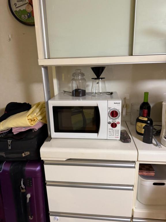 a microwave sitting on top of a kitchen counter at 童童民宿 in Tokyo