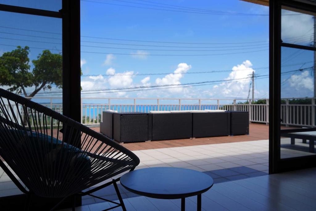 北中城村にあるVILLA fantasia Okinawa Kitanakagusukuの海の景色を望むバルコニー(椅子、テーブル付)