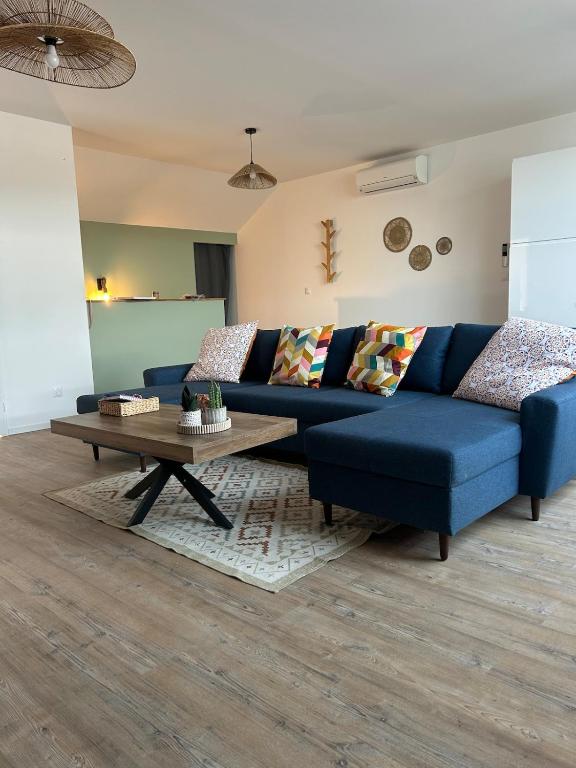 a living room with a blue couch and a coffee table at La bulle colorée in Saint-Aubin-lès-Elbeuf