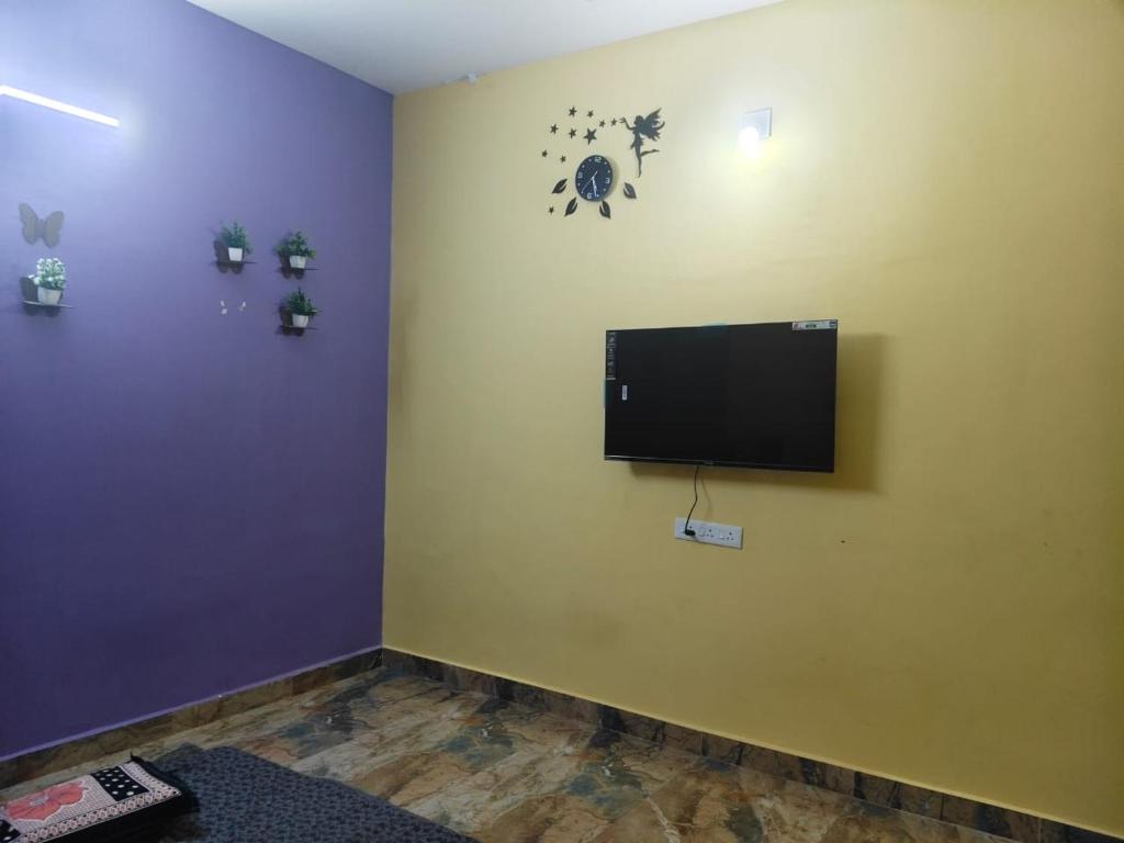 a room with a flat screen tv on a wall at Rasamb sejour villa in Villupuram
