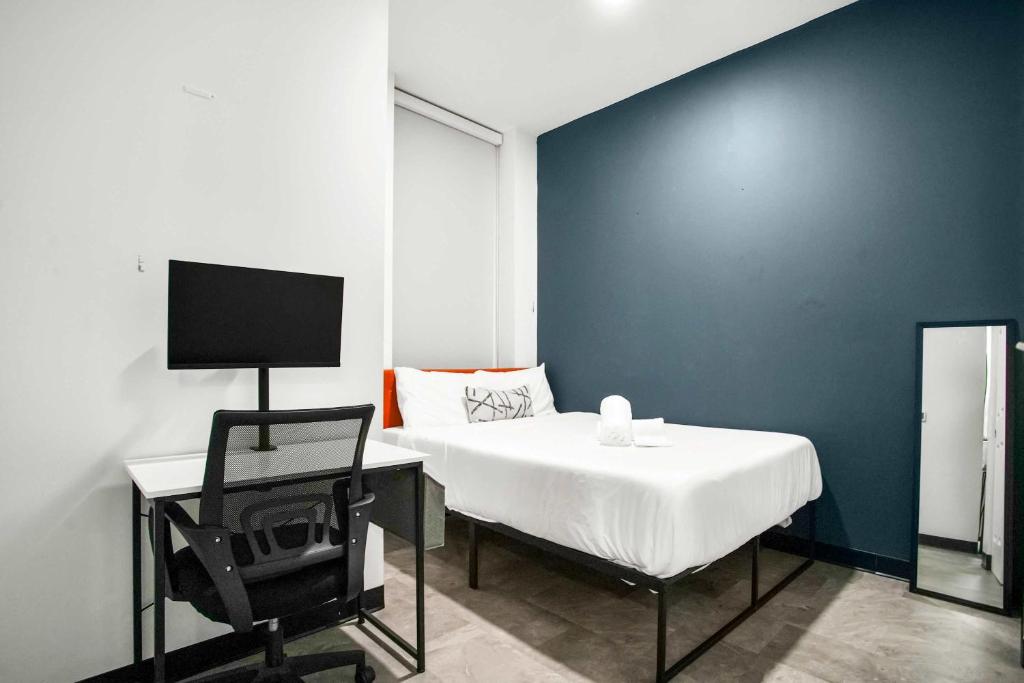 a bedroom with a bed and a chair and a desk at CozySuites Stunning 1BR in Downtown Pitts 44 in Pittsburgh