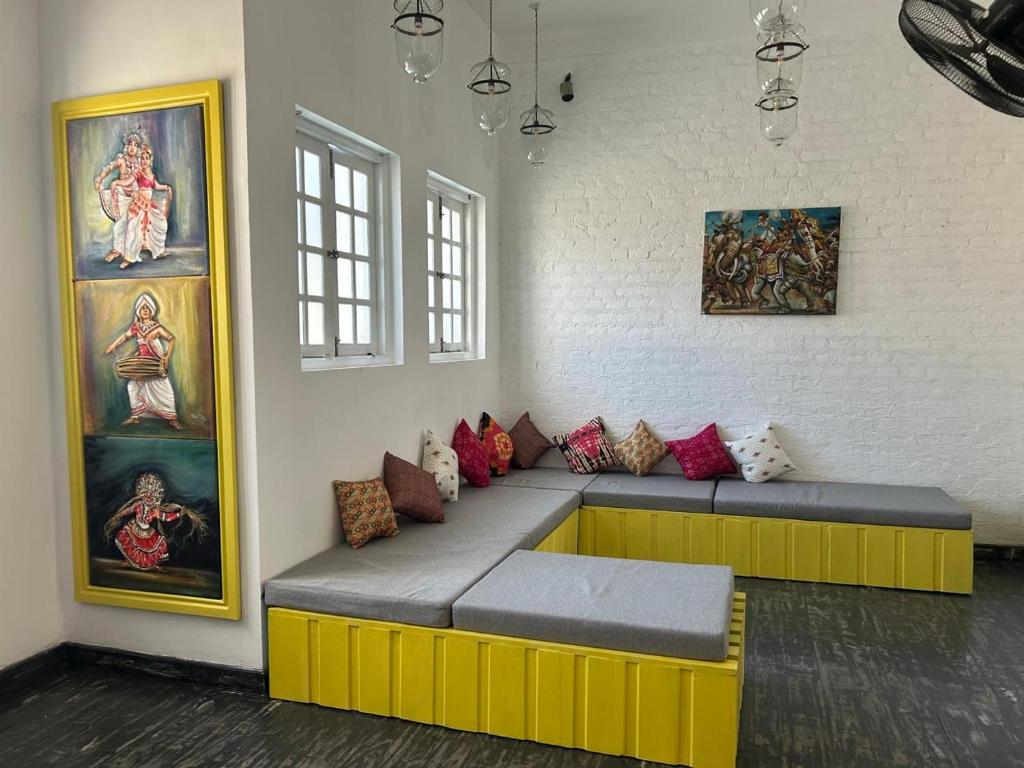 a couch in a room with paintings on the wall at Candea Cocoon Kandy in Kandy