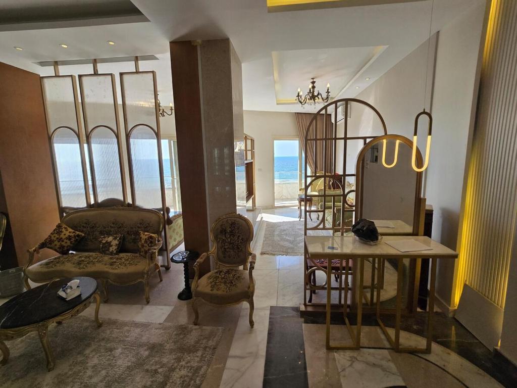 a living room with a mirror and a table and chairs at Sea Apartment -Families Only in Alexandria