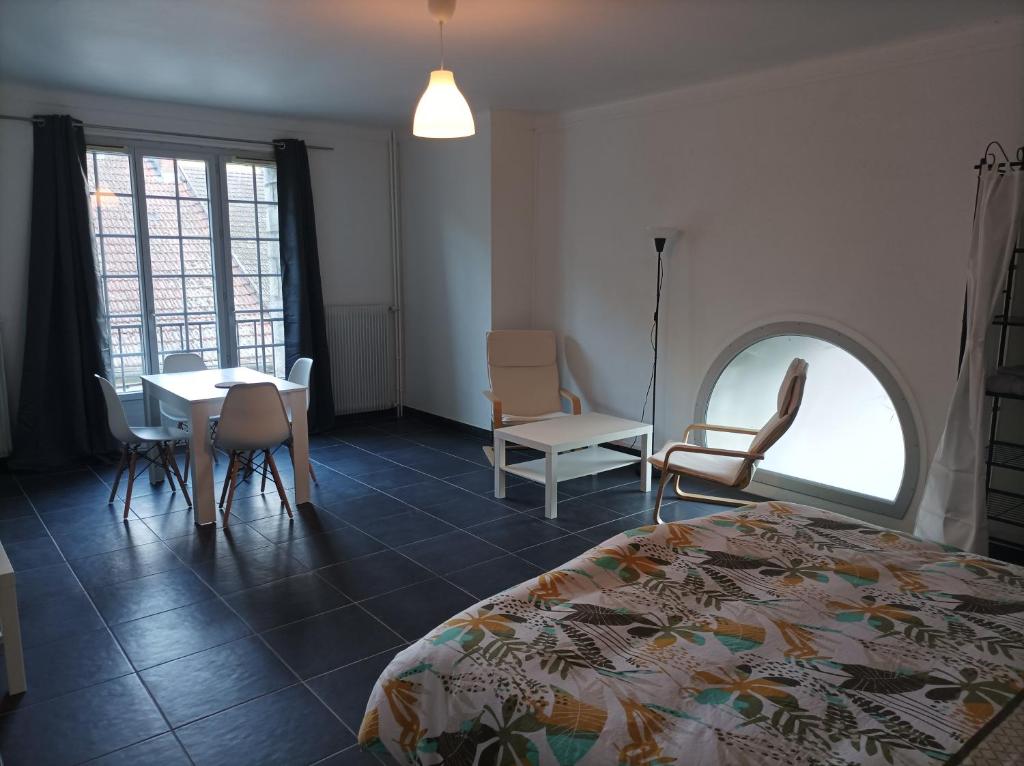 a bedroom with a bed and a table and chairs at O'Couvent - Appartement 242 - 1 chambre - 72m2 - Quatrième étage in Salins-les-Bains